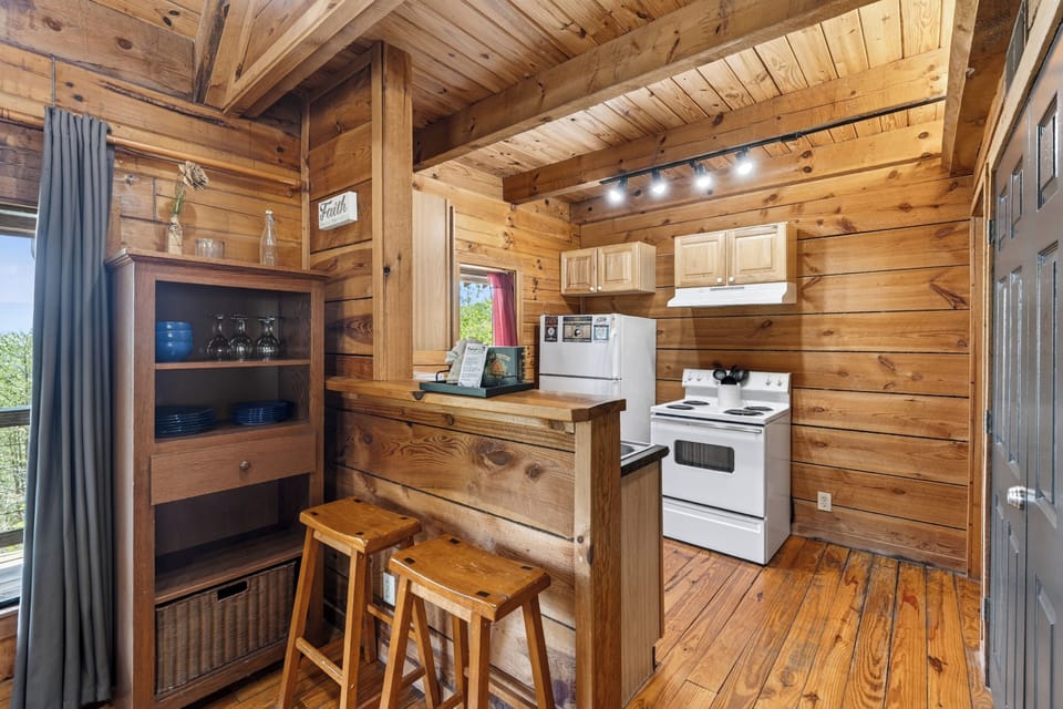 Warm wood‑planked cabin kitchen with simple essentials, soft natural light, and a cozy rustic charm.
