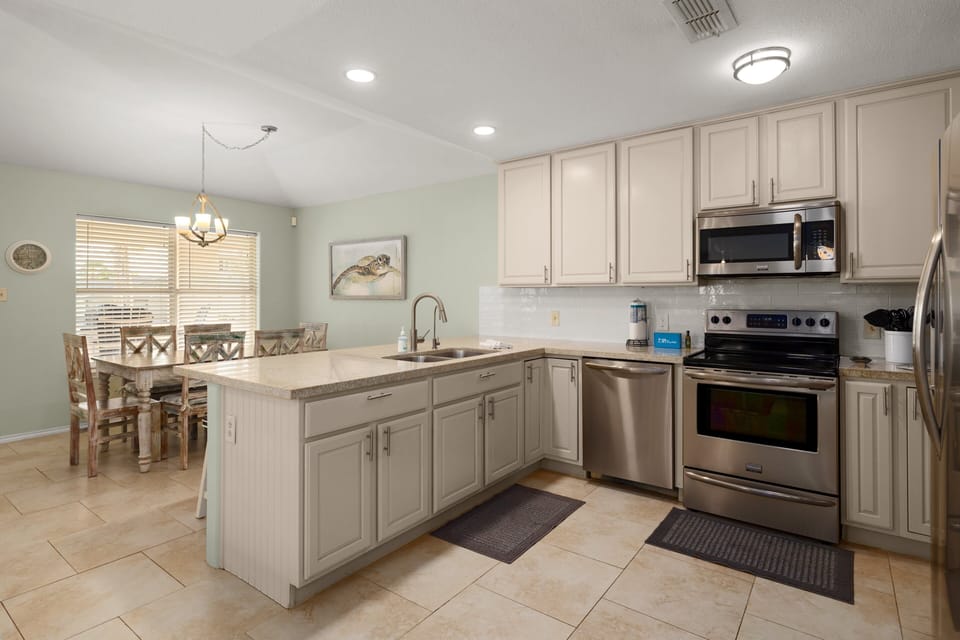 Cook with ease in a full kitchen featuring stainless appliances and bar seating