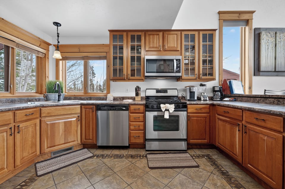 Your fully equipped kitchen at 21 GCR 4435 features warm wood cabinets, granite counters, and stainless appliances perfect for preparing memorable mountain meals together.