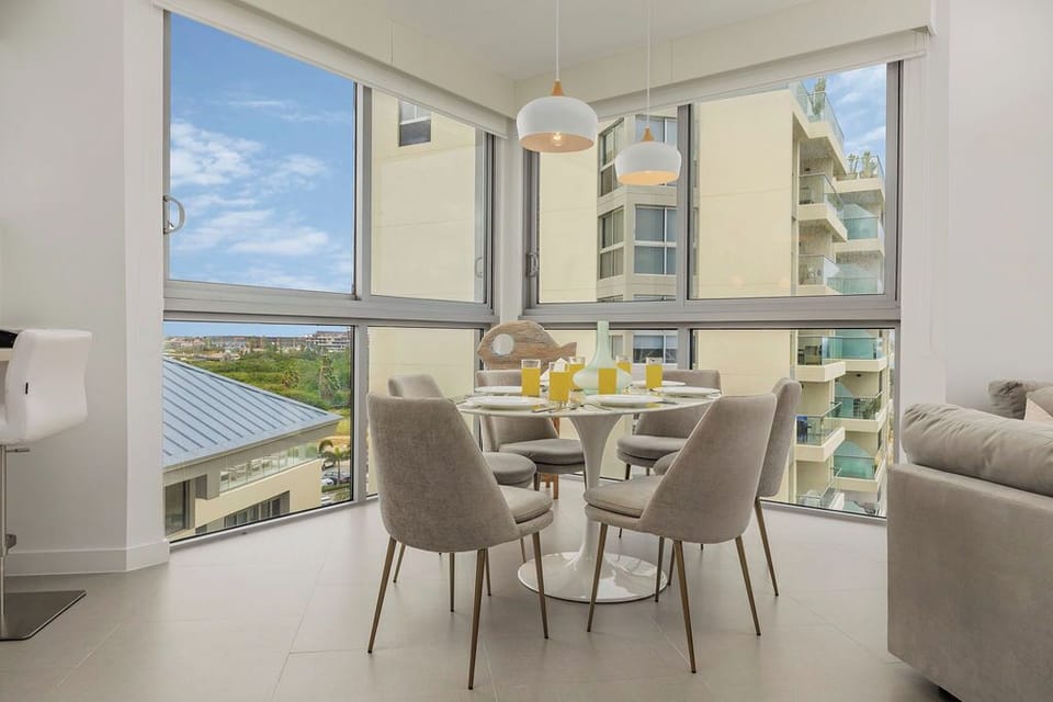 Savor breakfast with sweeping city views through floor-to-ceiling windows while stylish pendant lights create the perfect morning ambiance in your dining space.