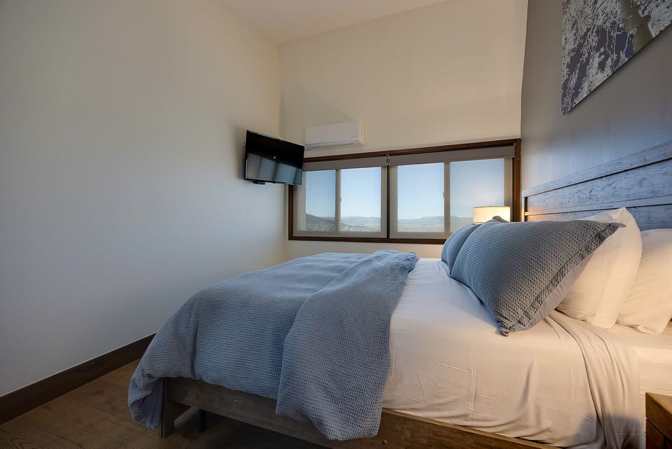Drift off to sleep in crisp linens while mountain views fill your window. The wall-mounted TV lets you unwind after days exploring.