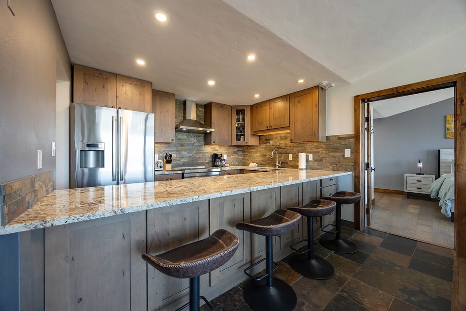 Your spacious kitchen features granite counters, stainless appliances, and a breakfast bar perfect for morning coffee or evening wine.