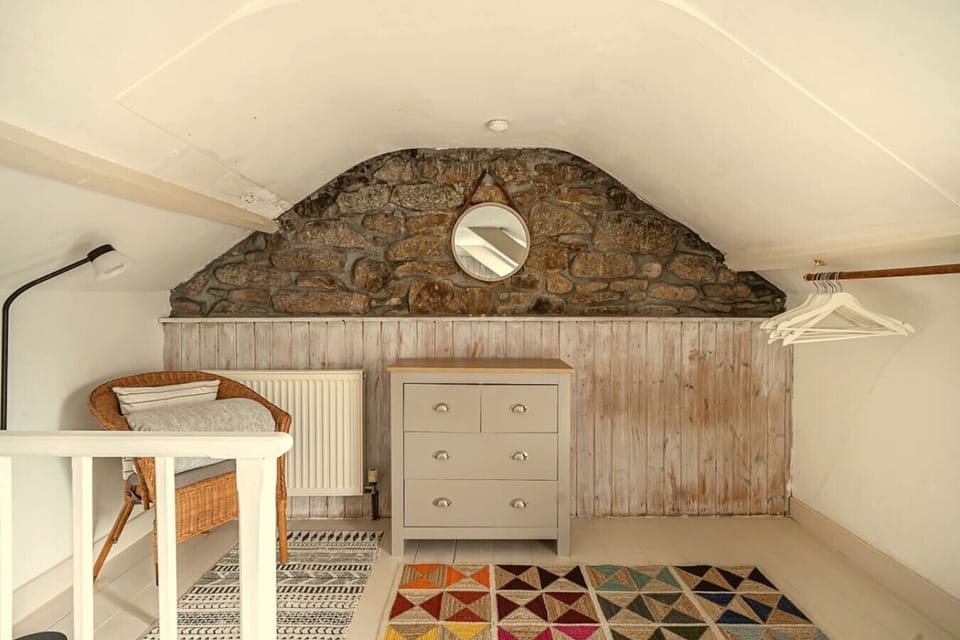 Exposed granite wall brings centuries of character to the attic landing.