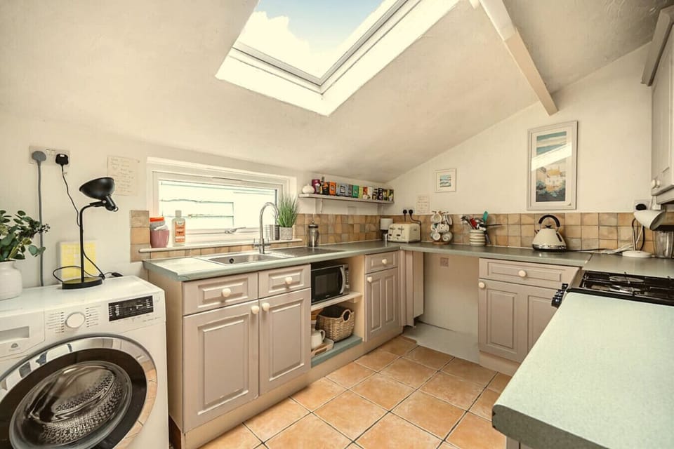 Bright skylit kitchen with gas hob, microwave and washing machine all included.