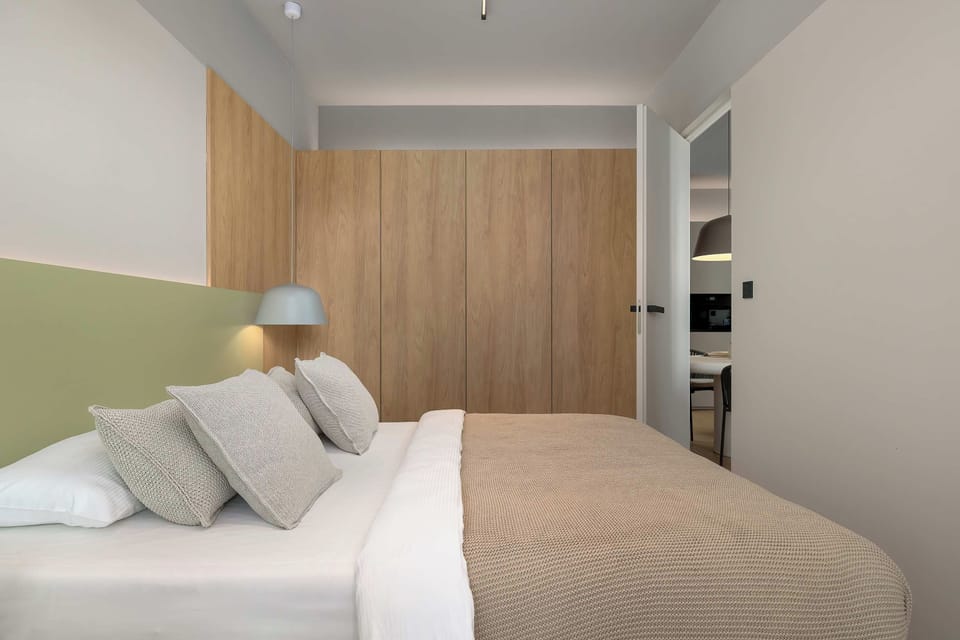 A peaceful bedroom with a large bed, warm lighting, and a window beside the sleeping area.