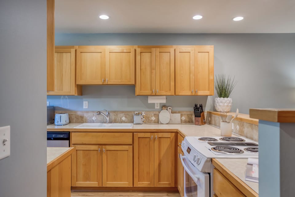 Your fully equipped kitchen awaits with warm wood cabinets, modern appliances, and everything you need to create memorable meals during your stay.