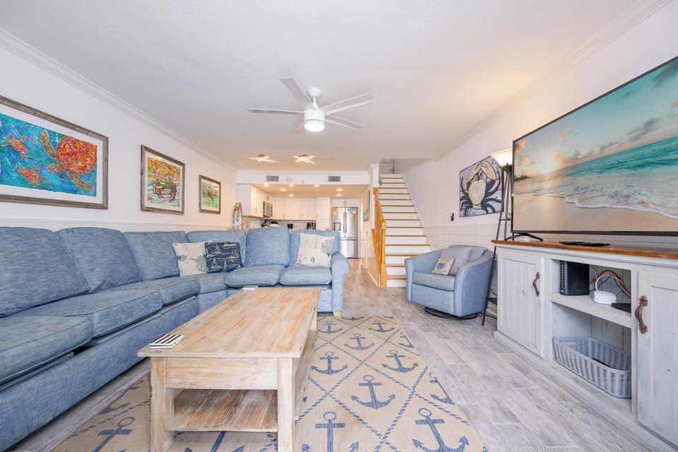 You settle into the plush sofa in the living room as coastal artwork surrounds your relaxing space