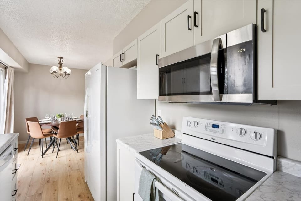 Kitchen | Unit 1 | Main Floor
Full kitchen with electric range and oven, microwave, and full-size refrigerator. Counter space for meal preparation and cabinet storage. Located adjacent to the dining area.