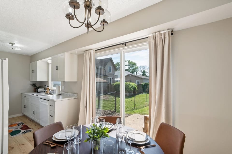 Dining Area | Unit 1 | Main Floor
Dining table with seating for four guests. Located next to the kitchen for easy meal prep and serving. Sliding glass door provides direct access to the backyard patio. Shared dining space within Unit 1.