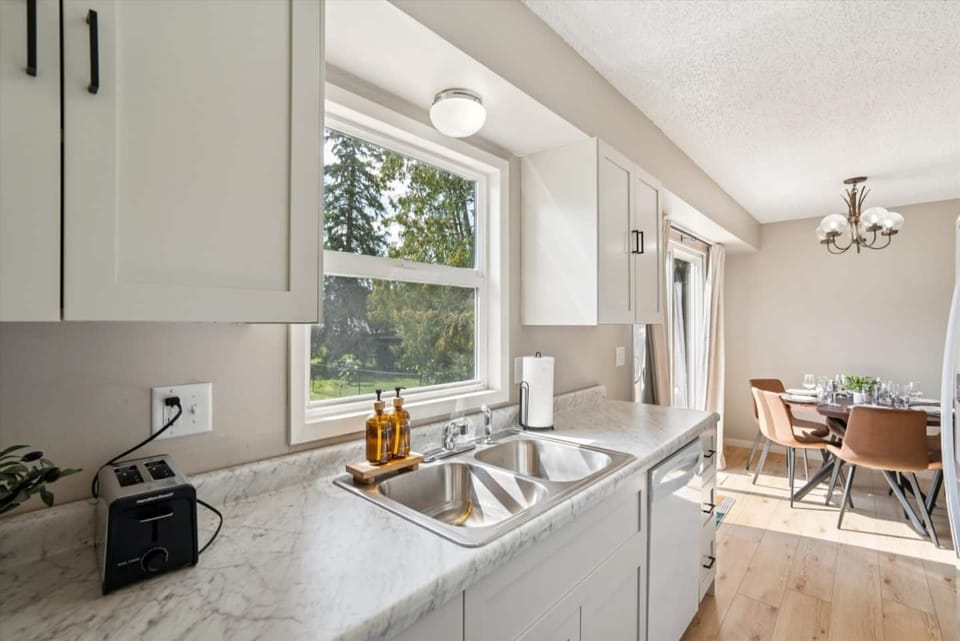 Kitchen | Unit 1 | Main Floor
Full kitchen with double-basin sink. Electric range and oven, microwave, dishwasher, and full-size refrigerator. Counter space for food preparation and cabinet storage. Window above the sink.