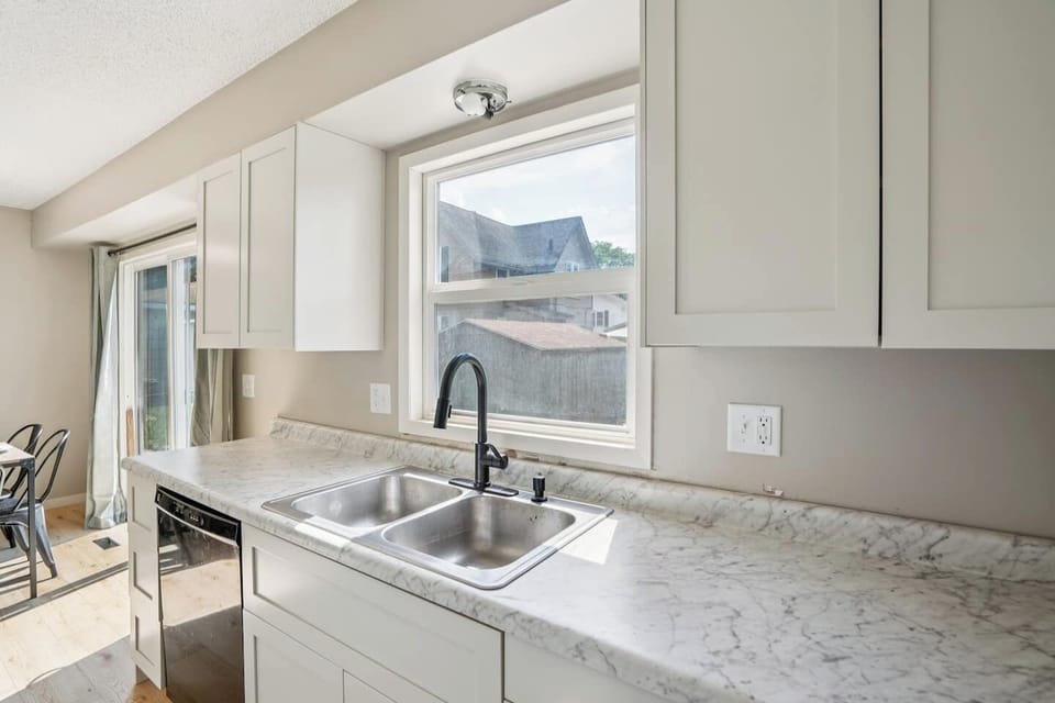 Kitchen | Unit 2 | Main Floor
Full kitchen with double-basin sink, dishwasher, electric range and oven, microwave, and full-size refrigerator. Counter space for meal preparation and cabinet storage. Window above the sink.