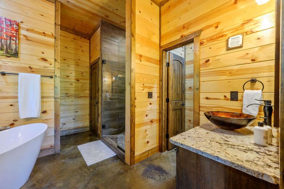 A single vanity, soaking tub, & shower await in this king ensuite​