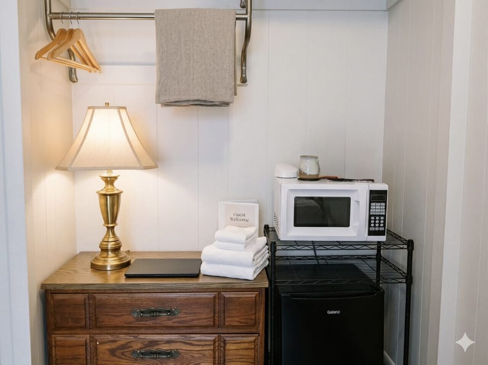 In-room amenity station with microwave, fresh towels, and a welcome basket for guests