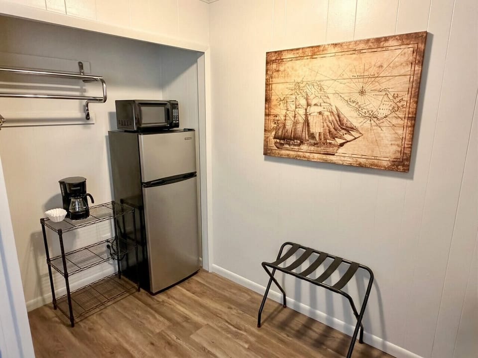 In-room mini fridge, microwave, luggage rack, and vintage nautical ship artwork