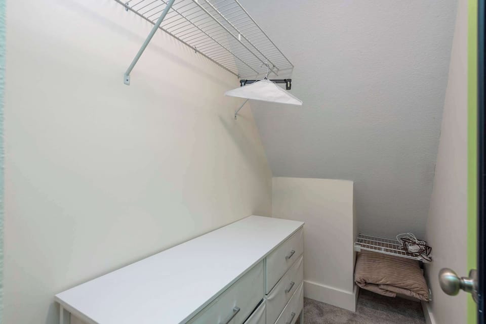 Keep your belongings tidy and out of sight during your stay. This convenient walk-in storage area features a full dresser and sturdy wire shelving, providing ample space for suitcases, clothing, and gear.