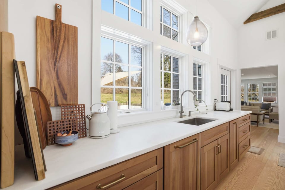 The sink sits beneath a wide window looking out to the yard — good light, good views, and plenty of counter space for cooking.