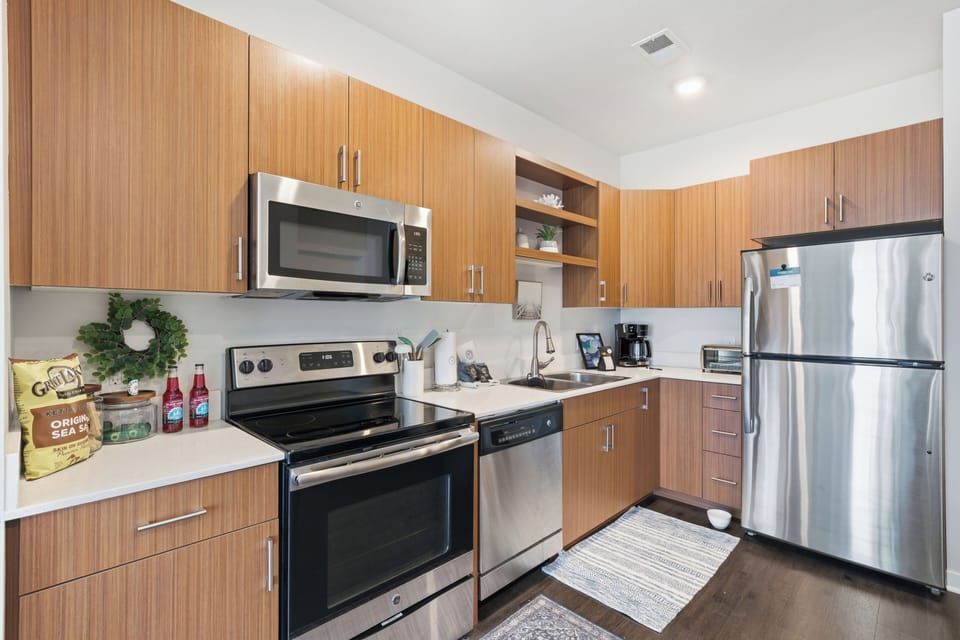 Full kitchen with modern wood cabinetry, stainless steel appliances, and all the essentials for your culinary needs.