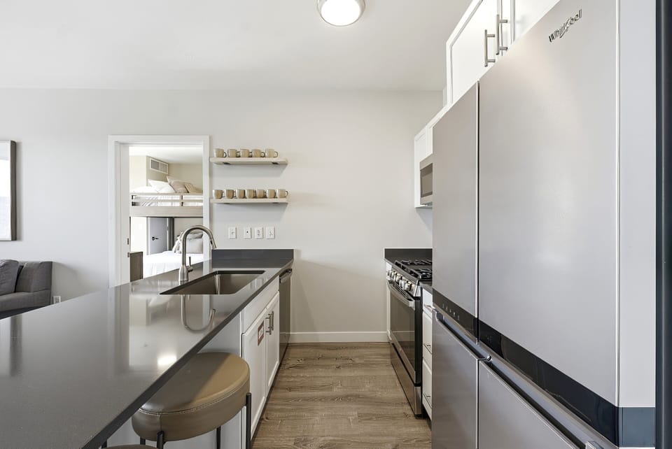 Sleek modern kitchen with stainless steel appliances, bar seating, and clean, contemporary finishes