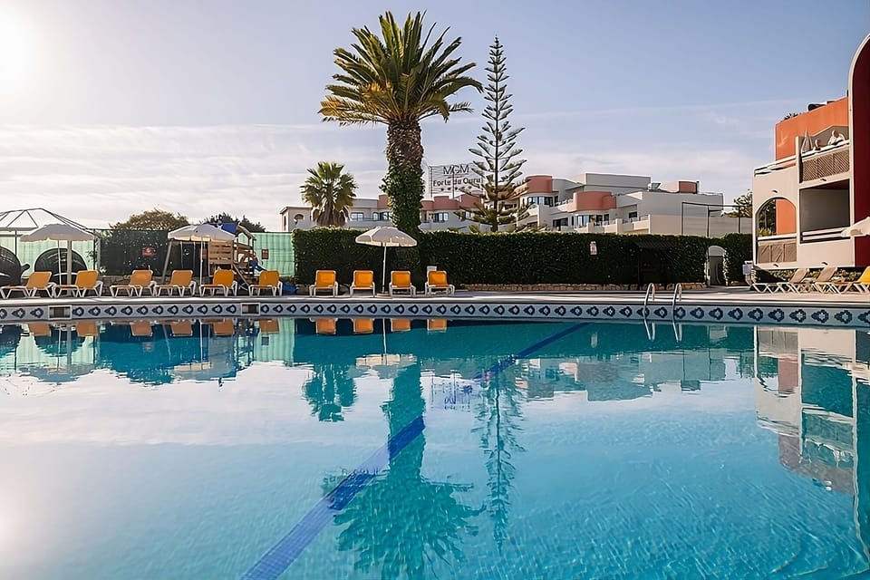 Dive into crystal-blue water beneath swaying palms and calm skies.