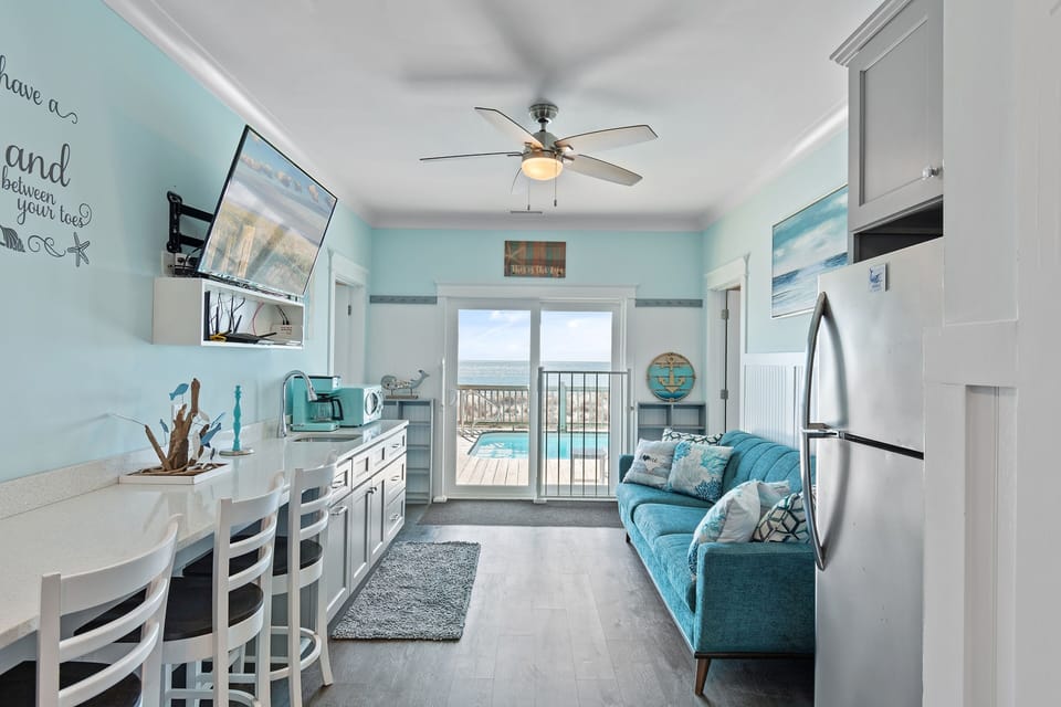 Convenient kitchenette with sink, mini-fridge, and storage — ideal for prepping drinks and snacks before heading to the pool or beach.