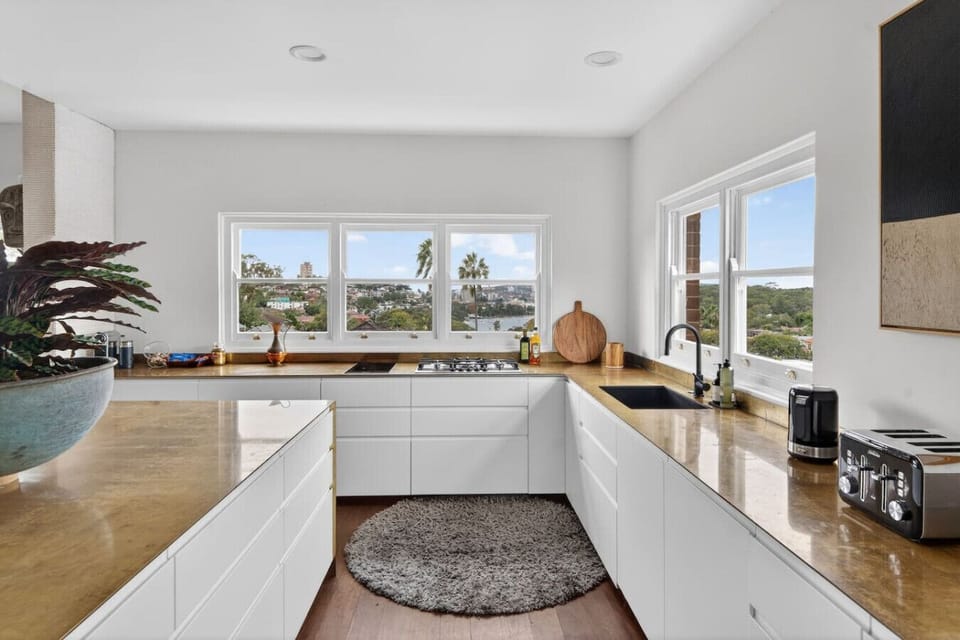 Bright kitchen with modern appliances, wooden countertops, and window views.