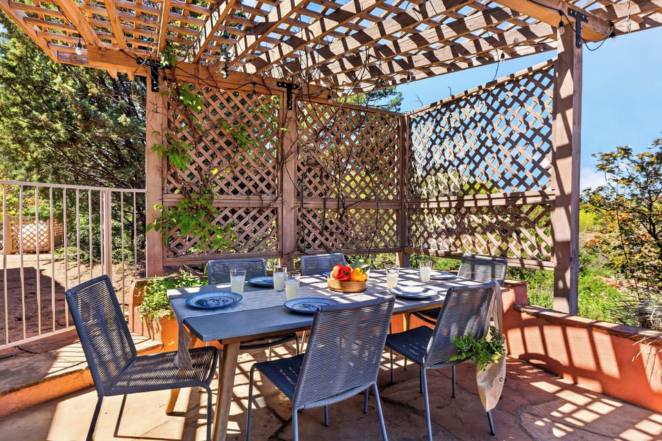 Dine al fresco beneath a shaded pergola, surrounded by lush greenery and peaceful Sedona views.