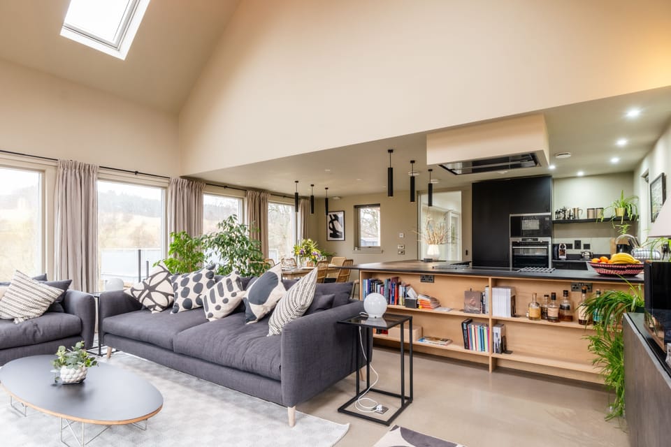 The open-plan living space is flooded with light and full of high-spec appliances