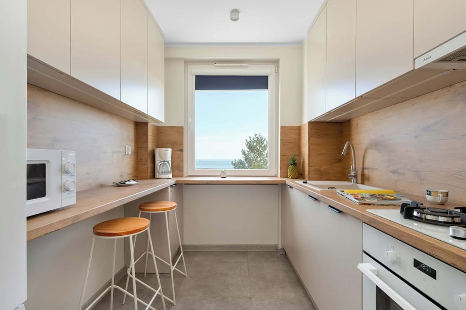 This is a closer view of the kitchen counter from Photo 3, with the white microwave now clearly visible at the far end of the counter, next to the built-in sink.