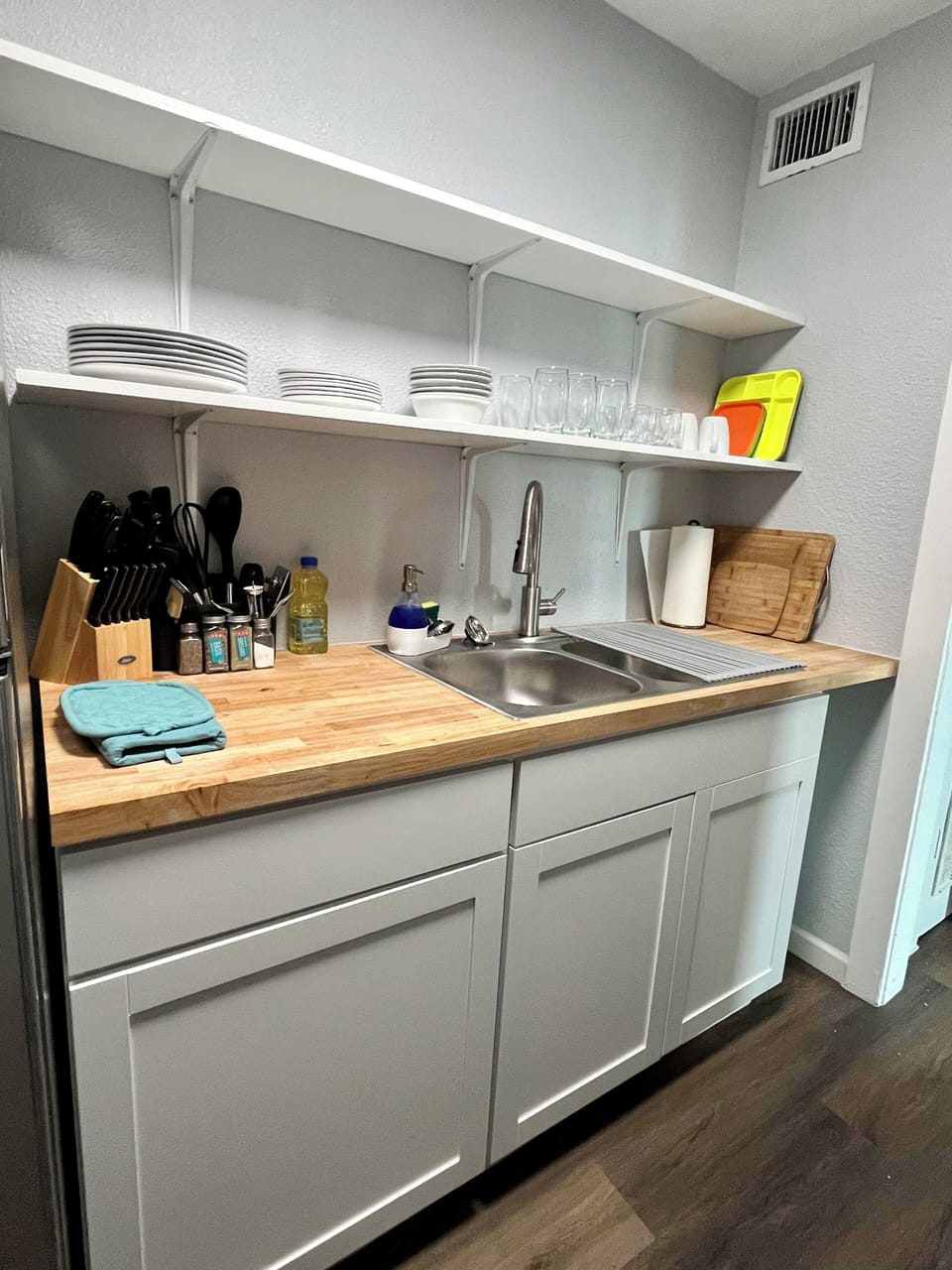Modern convenience meets style—enjoy a deep double sink, butcher block countertops, and organized open shelving.