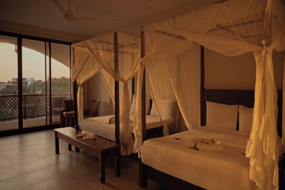 Share sunset serenity in a spacious suite with two canopies.