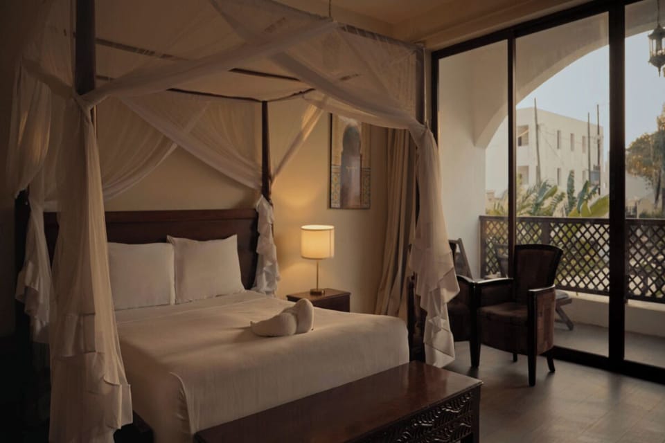 Unwind in a dreamy canopy bed beside your private balcony.