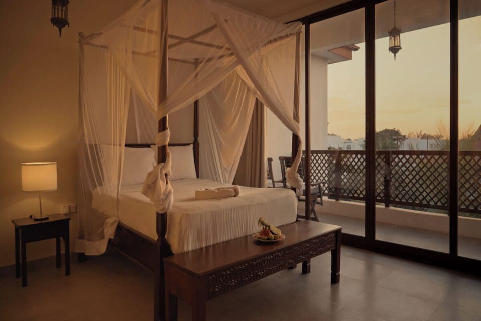 Wake to golden sunset views from this romantic canopy suite.