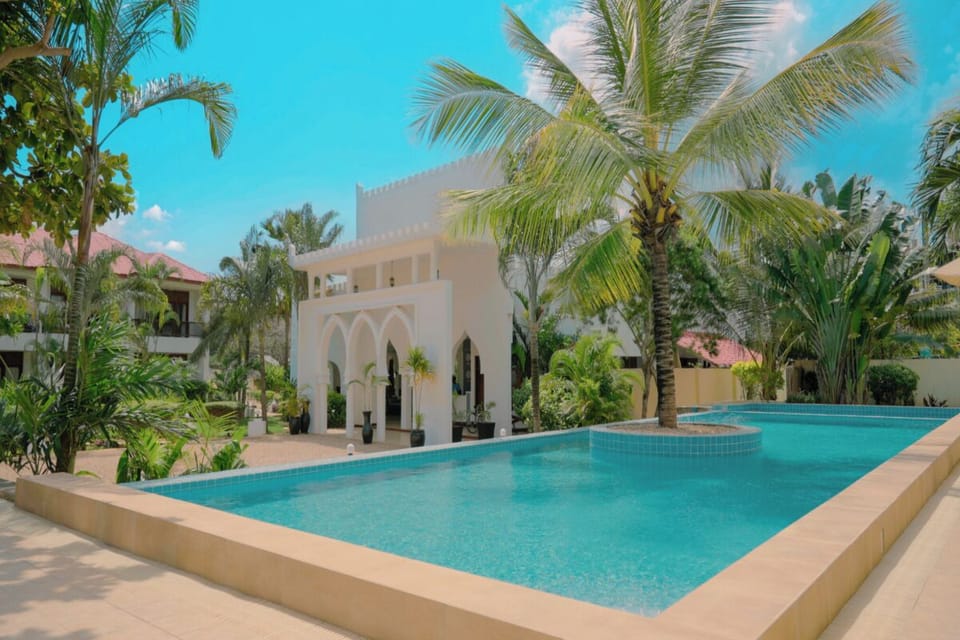 Dive into sunlit serenity beside the palms and arches.