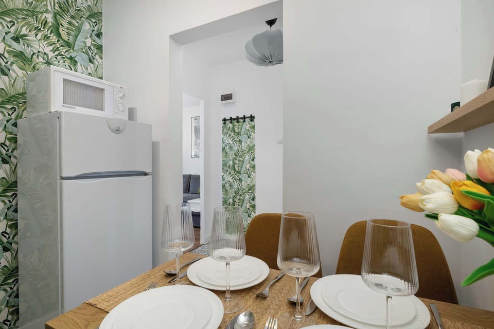 A kitchen corner with a refrigerator, countertop space, and dishes prepared on a small table.