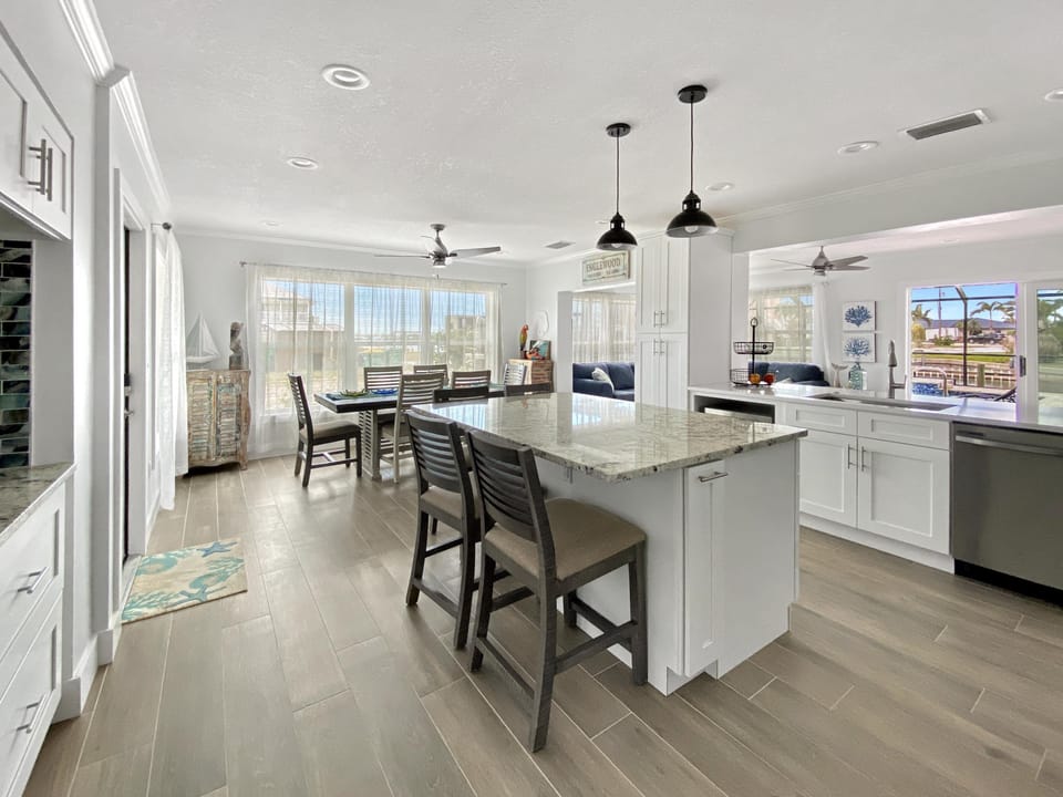 Modern kitchen with granite island and dining area, perfect for family gatherings.