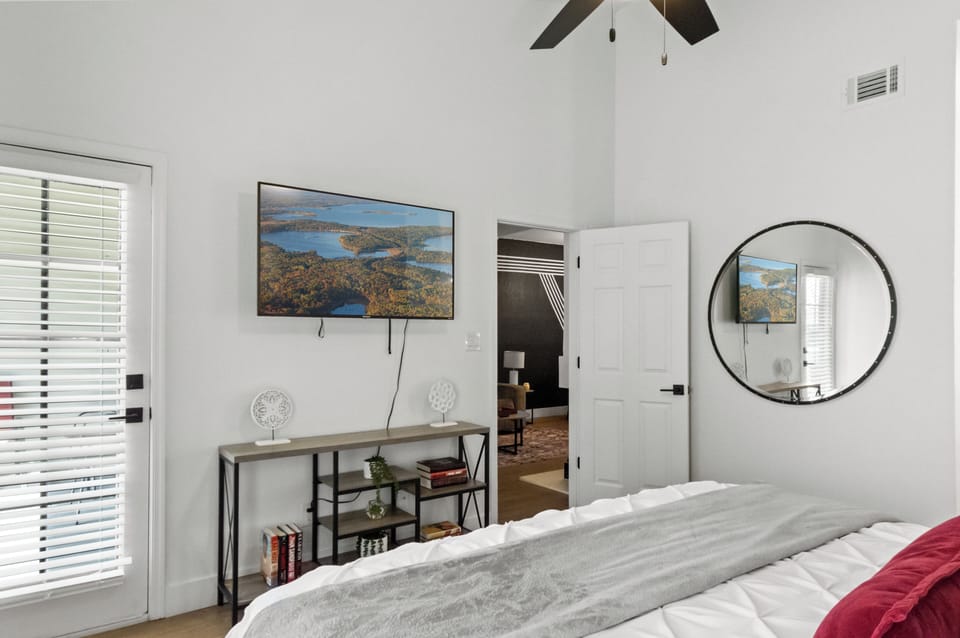 Bright bedroom featuring a comfortable bed and convenient TV.