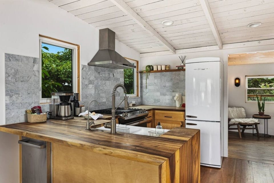 The coffee corner — grinder, drip machine, retro-style fridge, and a tiled backsplash.