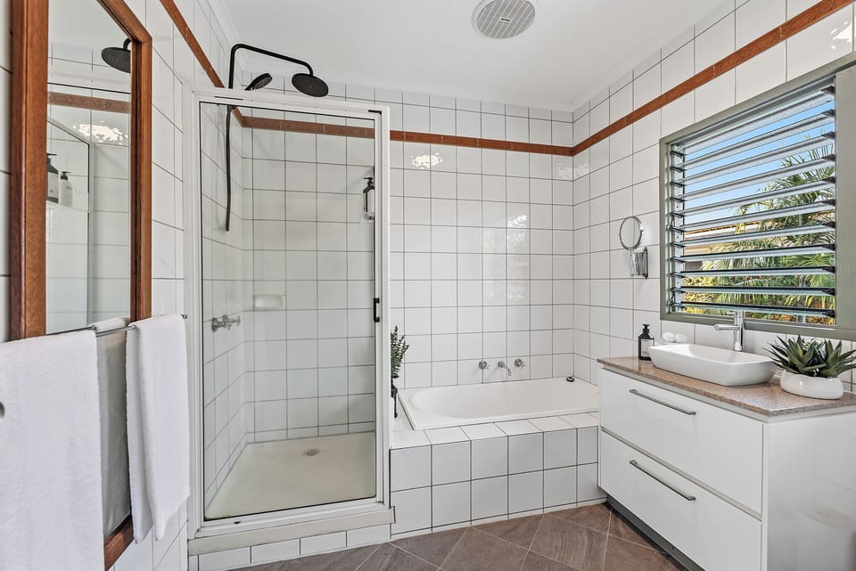 Refresh and reset in the main bathroom, where a walk-in shower, separate bathtub, and clean, light-filled design create an easy space to start or end your day.