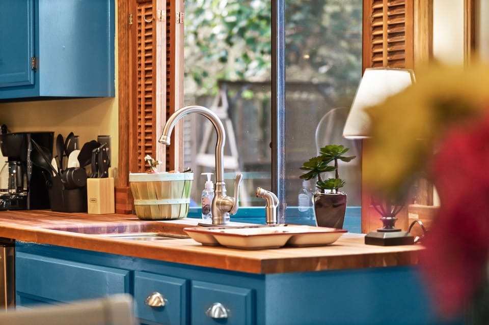 You’ll enjoy a warm, modern kitchen with bold blue cabinets and natural wood countertops, creating a stylish yet cozy space to cook and gather.