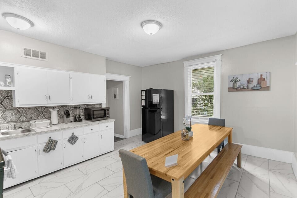 Enjoy meals together in the open kitchen and dining area, featuring a fully equipped kitchen and a cozy table perfect for gathering.