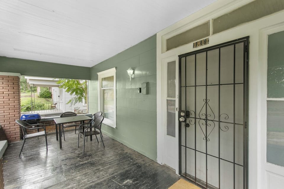 Start your stay on the inviting covered front porch, where you’ll find a welcoming entrance and a cozy outdoor dining setup—perfect for morning coffee or relaxed evening meals.