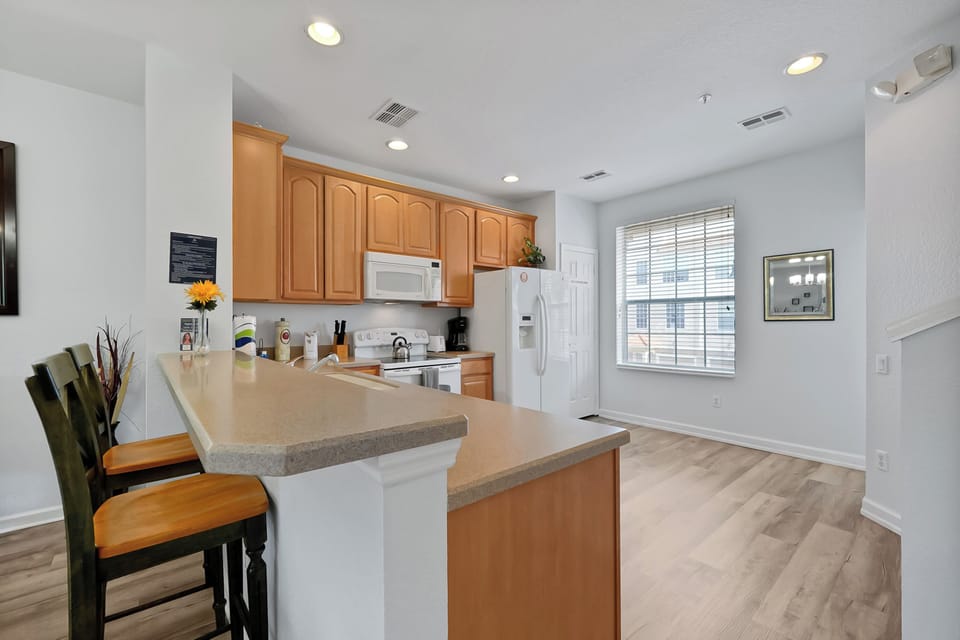 Your spacious kitchen features warm wood cabinets, granite counters, and a breakfast bar where you can enjoy morning coffee.
