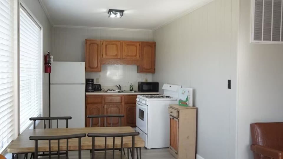 Cook together with fridge, stove, and cozy dining table.