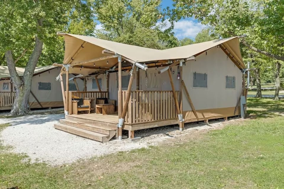 Arrive to your private canvas lodge nestled under tall trees.