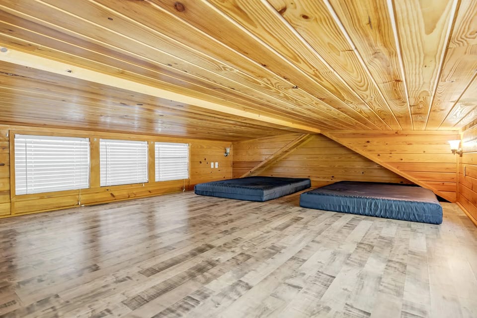 Stretch out in a spacious loft sleeping area under timber ceilings.