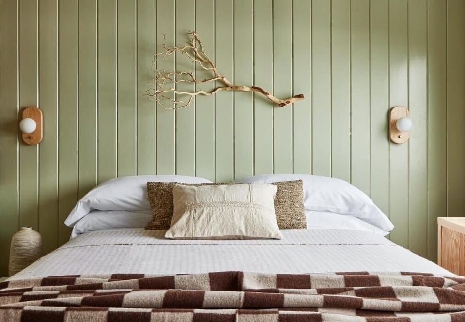 Drift off beneath warm sconces and nature-inspired wall art.