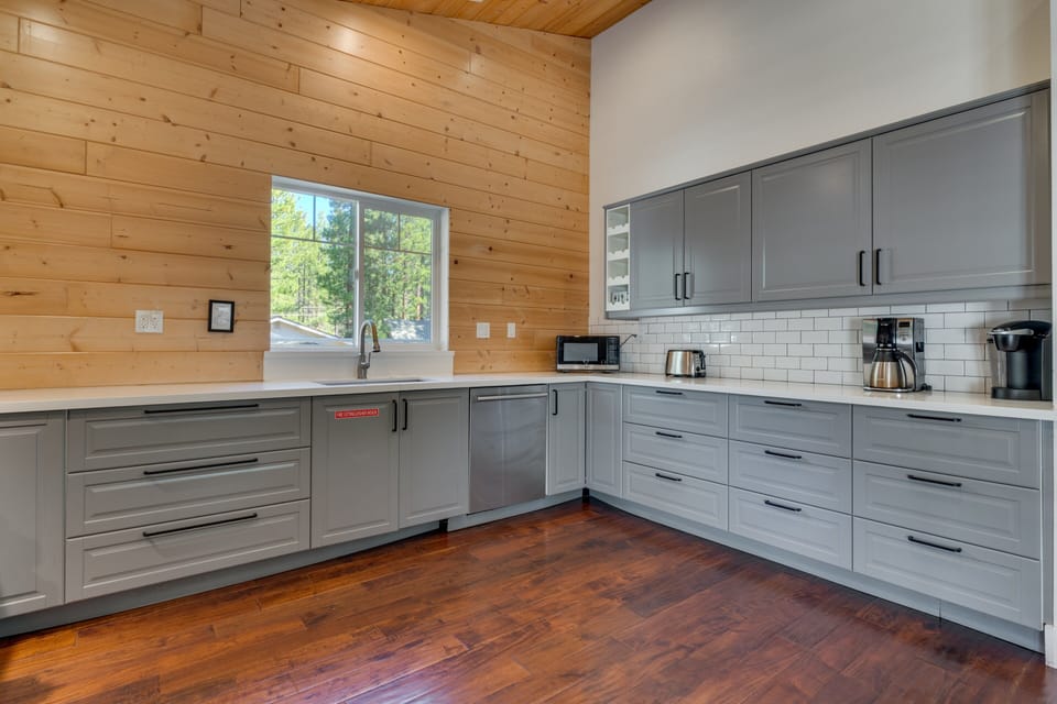 Bright kitchen w/ generous counter space, stainless appliances & warm cabin-inspired finishes