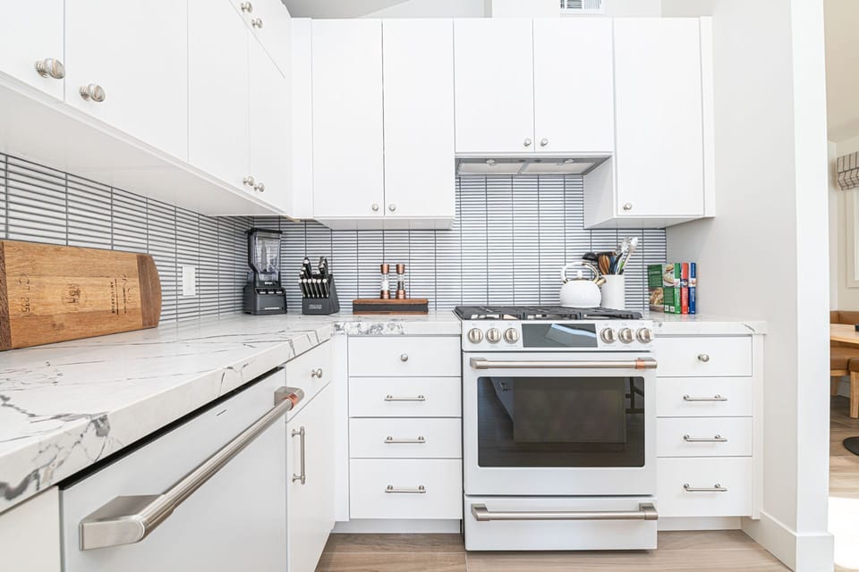 Beautifully updated kitchen with crisp white cabinetry, modern appliances, and a clean coastal aesthetic.
                
