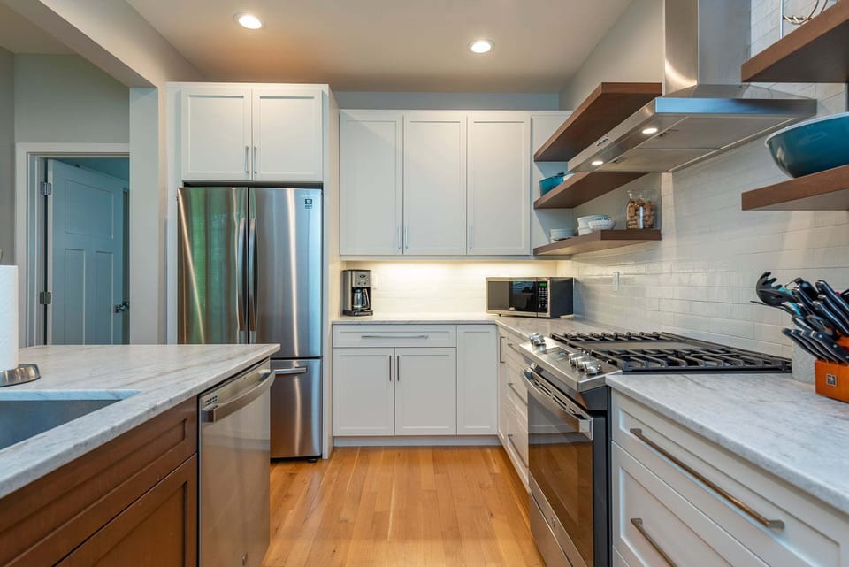 Kitchen with spacious island, gas range, dishwasher, and drip-style coffee maker