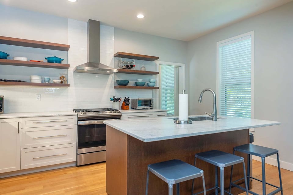 Kitchen with spacious island, gas range, dishwasher, and drip-style coffee maker